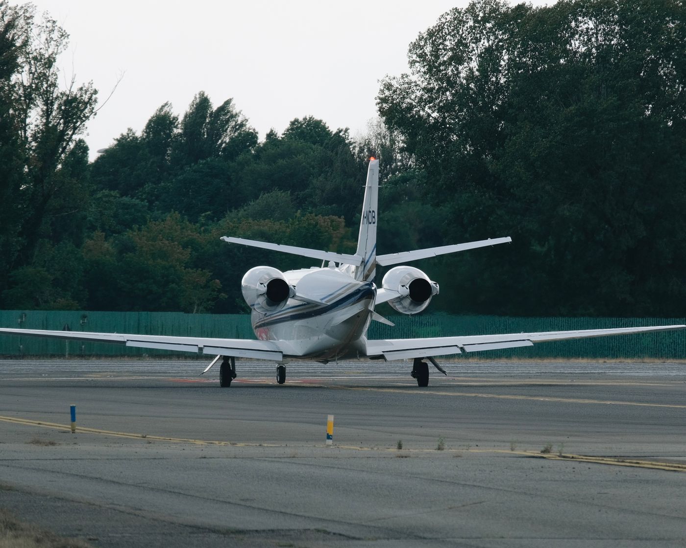 A private jet on the apron, trees beyond